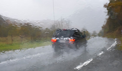 Fototapeta premium windshield with water drops and car on the road