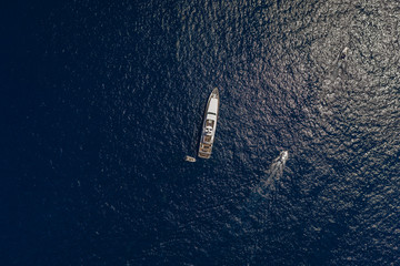 Aerial overhead drone shot of luxury yacht in Tyrrhenian sea near Capri Island in summer