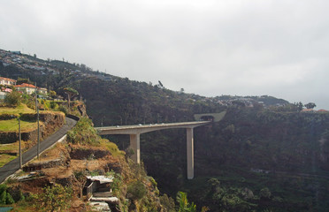 aerial panoramic view of the city of funchal with bridges and roads in front of buildings on the...