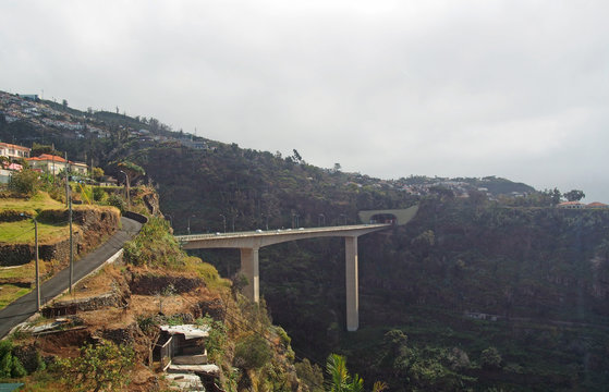 aerial panoramic view of the city of funchal with bridges and roads in front of buildings on the mountains