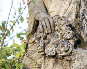 Monument and candles in the cemetery. All Saints Day in Poland. Stone angel. Stone statue. Stone flowers. Stone plants. Stone cross.