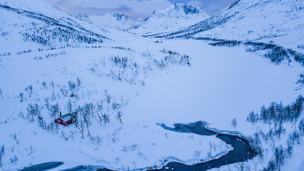 Rivière prise dans la glace et la neige dans un pyasage arctic en Norvège
