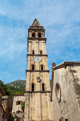 Fototapeta na wymiar the ancient temple , the bell tower with a wall clock, Perast, Montenegro