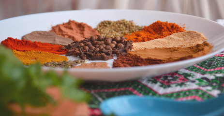 Set of oriental spices in a plate on a wooden table. Parsley, basil, cilantro. View from above.