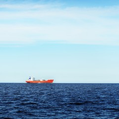 View of a distant red lpg tanker sailing in a open sea on a clear day