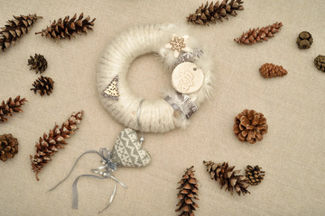 Decorated handmade Christmas wreath and pine cones on the table. Top view.      