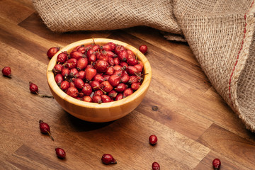 Wooden cup full of rose hips
