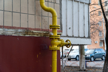 Yellow gas valve with flywheel and flanges on the curvy conduit with two 90-degree elbow