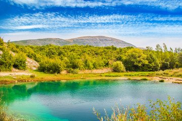 Croatia, Cetina river source water hole and Dinara mountain in background, Dalmatian Zagora karst landscape