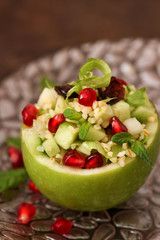 Raw apples stuffed with salad with bulgur, cucumbers and pomegranate seeds