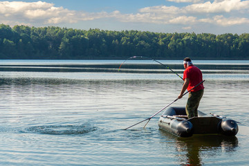 Fototapeta na wymiar A fisherman on a boat is fishing big fish.