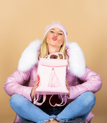 Backpack is all you need. Little backpack and knitted hat. Total pastel outfit. Tender combination. Matching accessories. Fashion accessory. Girl adorable model showing her fancy leather backpack