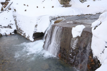 motion of Cold waterfall with snow monkeys sitting in the snow winter season in Japan.