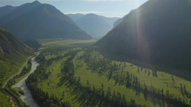 The majestic drone flight over an epic landscape in the highlands. Below, a river flows from a waterfall. 4K.