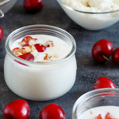 Fermented yogurt kefir in small bottles with cherries and walnuts