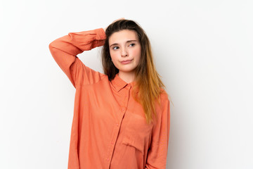 Young brunette girl over isolated white background having doubts while scratching head