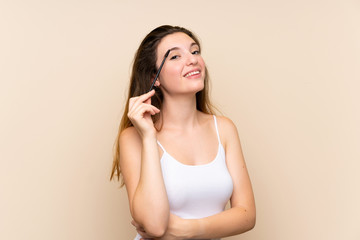 Young brunette girl applying mascara with cosmetic rush over isolated background