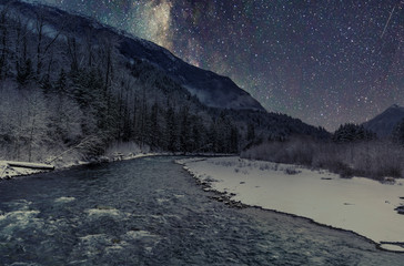 Magical Landscapes of the stars and the milky way with mountains and waterfalls with winter scenics for wallpaper backgrounds.