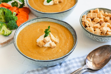 Cream vegetable soup broccoli, carrot, cauliflower with croutons. Vegetarian healthy food on light background