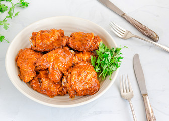 Baked Chicken Thighs Tossed in Buffalo Sauce, White Background
