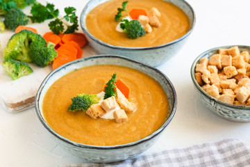 Cream vegetable soup broccoli, carrot, cauliflower with croutons. Vegetarian healthy food on light background