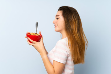 Young brunette girl holding a bowl of cereals over isolated background