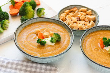 Cream vegetable soup broccoli, carrot, cauliflower with croutons. Vegetarian healthy food on light background