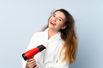 Young woman in a bathrobe with hair hairdryer