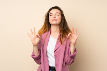 Young brunette girl with blazer over isolated background in zen pose