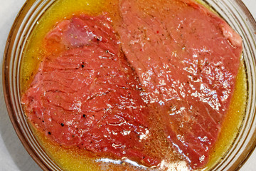 raw beef steak soaked in sauce, fragment 	