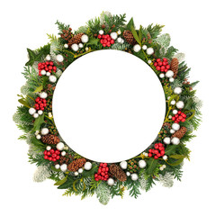 Fototapeta na wymiar Christmas decorative table setting with round porcelain plate, silver bauble decorations & winter greenery and holly on white background with copy space.