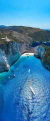 Portrait aerial drone shot of Zakynthos Navagio beach with yachts and cruise ship in Ionian sea in Greece
