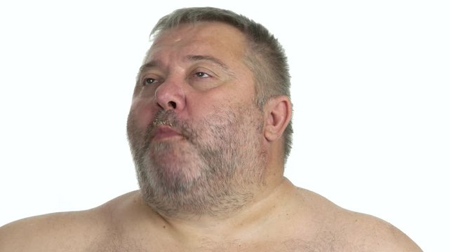 Portrait of fat man enjoying breakfast. Satisfied obese guy chewing food on white background close up. Overeating leads to health problem.