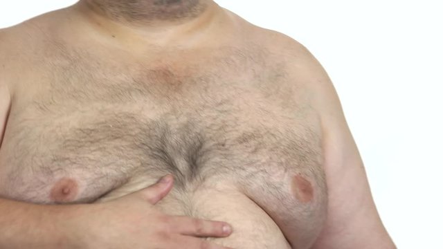 Joyful thick man with big belly. Happy fat man touching his big belly with hands after well eating. Overeating problem.