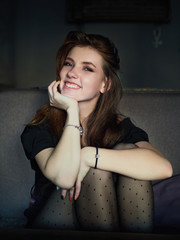 Portrait of a cute pretty redhead woman sitting in a cafe enjoying free time coffee break еhoughtfully looking into camera hugging knees