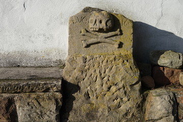 Historischer Grabstein mit Totenkopf in Essingen in der Pfalz