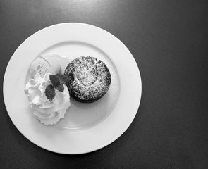 Hot chocolate fondant with ice cream and cream on a plate
