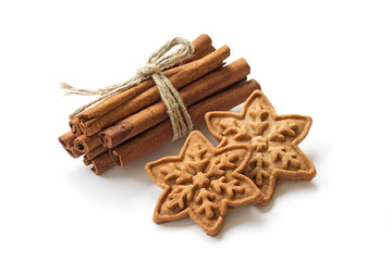 Cinnamon sticks with christmas cookies on white backgroun
