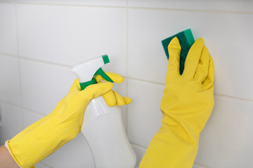 hand in protective glove holding spray. cleaning a kitchen concept