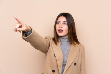 Young woman over isolated background pointing away