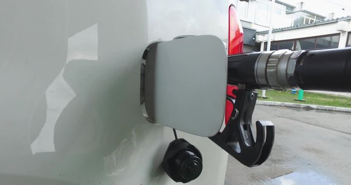 Refueling in a white car, a closeup view of the refueling process at a gas station.