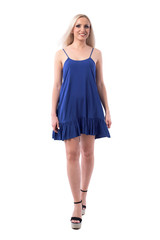 Happy excited blonde fashion catwalk girl in blue dress walking and smiling. Full body isolated on white background. 