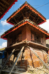 An ancient collapsing Hindu three-story temple on a stone pedestal with wooden pillars. Durbar Square in Kathmandu, Nepal