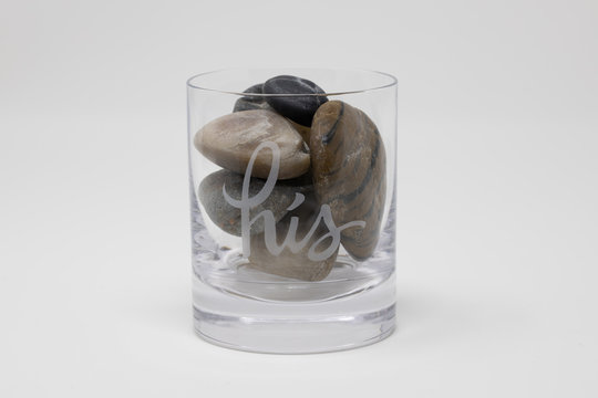 Neutral Colored Rocks In A High Ball Cocktail Glass With 'his' Etched On Side Photographed In Hi-key