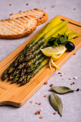  tasty asparagus on a wooden stand with lemon