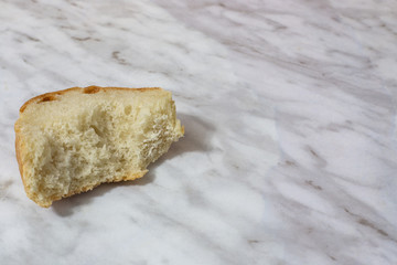 bitten piece of old white bread on the table