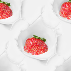 Strawberries fall into the cream with a splash