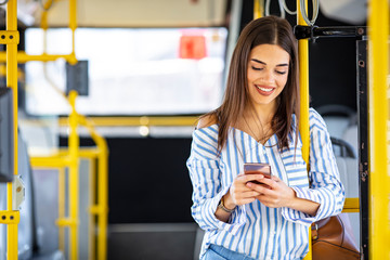 A young lady using a smartphone on the bus. The passenger use smartphone in the bus or train, technology lifestyle, transportation and traveling concept. Woman Reading Text Message On Bus © Dragana Gordic