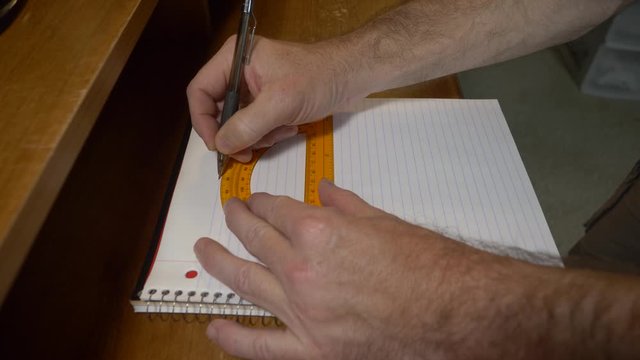 Man using a protractor to draw a right angle for studying geometry, drawing on paper, doing math homework.