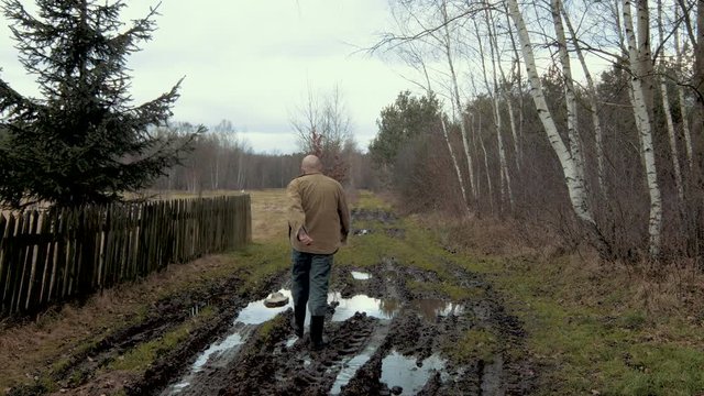 The man is walking on mud and water. high-quality footage shot with a film camera and lens.
